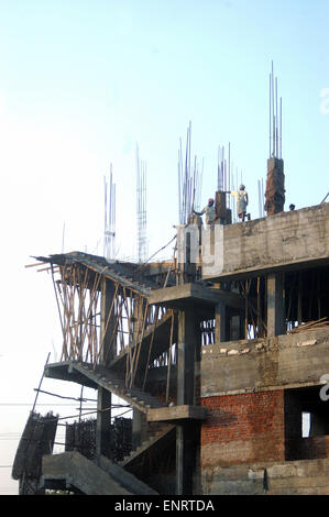 Men on skyline of construction site, Tamil Nadu, South India Stock Photo