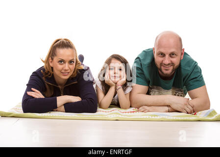 Happy three members of family laying on a blanket in a row against white background Stock Photo