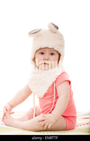 Beautiful baby girl in fluffy bunny hat  sitting on blanket Stock Photo