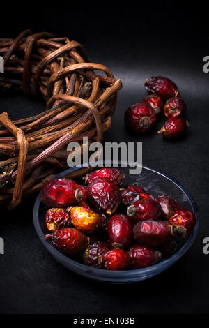 berries are dried rose hips and herbs on black background Stock Photo