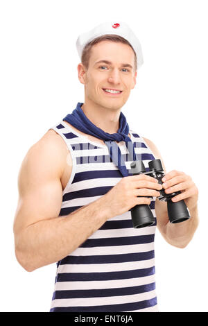Vertical shot of a male sailor holding binoculars, smiling and looking at the camera isolated on white background Stock Photo