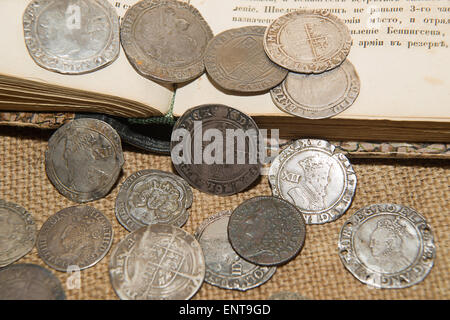 A lot of old England  silver coins with portraits of kings on the old cloth Stock Photo