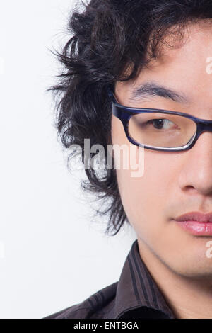 Asian young man wearing glasses looking away cropped Stock Photo