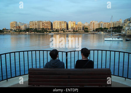 couple overlooking St Julian's Bay Malta Europe Stock Photo