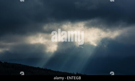 Sun rays break through the clouds in a dramatic stormy sky, UK Stock Photo