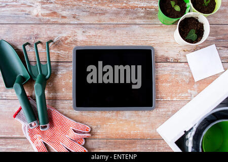 close up of tablet pc and garden tools on table Stock Photo