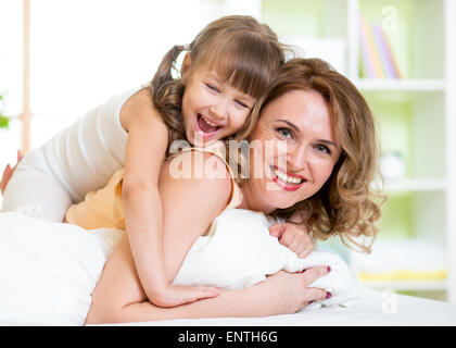 Happy mother and child girl having fun in bedroom Stock Photo