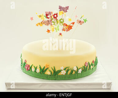 Birthday cake for first year of life, decorated with sugar butterflies and flowers, with number one on top. Stock Photo