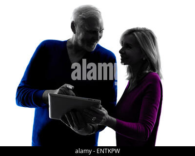 one caucasian couple senior looking at  digital tablet computer  silhouette  in silhouette studio isolated on white background Stock Photo
