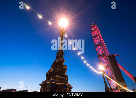 A lamp  and lights with strong flare on the South Bank, the London Eye is in the background Stock Photo