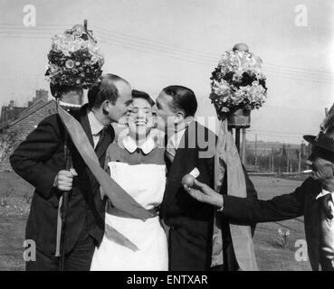 A Coin or a kiss for the Tutti-Men: The Hungerford Tutti-men exercised their traditional right today (19-4-55) and stopped women in the street, chased girls behind shop counters, and even climbed up ladders to reach them - all with a view either to extracting a coin from them, or a kiss. 19th April 1955 P029150 Stock Photo