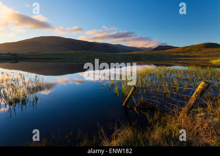 Low rigg reflected in Tewert Tarn after sunrise on a crisp spring day, English lake District Stock Photo