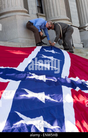 Civil war re-enactors position a gigantic Confederate flag on the steps of the South Carolina State Capitol building May 2, 2015 in Columbia, SC. Confederate Memorial Day is an official state holiday in South Carolina and honors those that served during the Civil War. Stock Photo