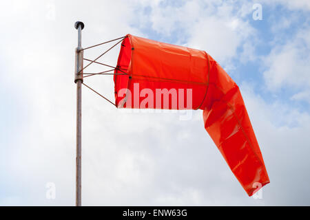 Windsock. Red wind indicator over blue cloudy sky Stock Photo