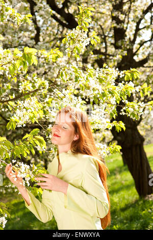 Young woman enjoying spring under blossom tree Stock Photo