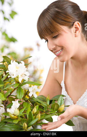 Gardening - Portrait of woman with Rhododendron flower Stock Photo