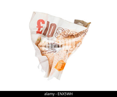 A British Sterling old paper ten pound note screwed up on isolated white background to illustrate money thrown away. England UK Britain Stock Photo