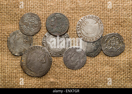 A lot of old England  silver coins with portraits of kings on the old cloth Stock Photo