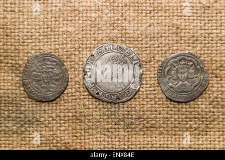 A lot of old England  silver coins with portraits of kings on the old cloth Stock Photo