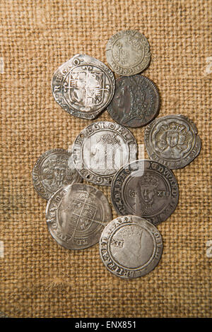 A lot of old silver coins with portraits of kings on the old cloth Stock Photo