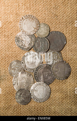 A lot of old silver coins with portraits of kings on the old cloth Stock Photo