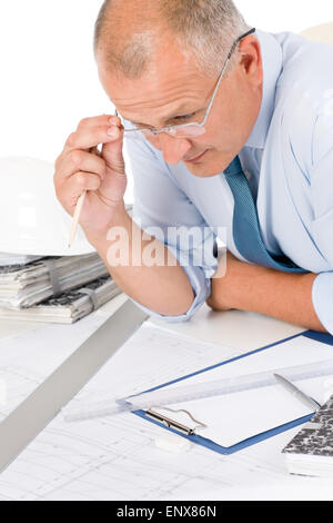 Professional architect with blueprint behind table Stock Photo