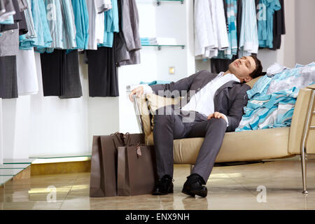 The client of shop of clothes sleeps on the sofa Stock Photo