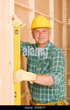 builder checking wooden beam with spirit level Stock Photo - Alamy