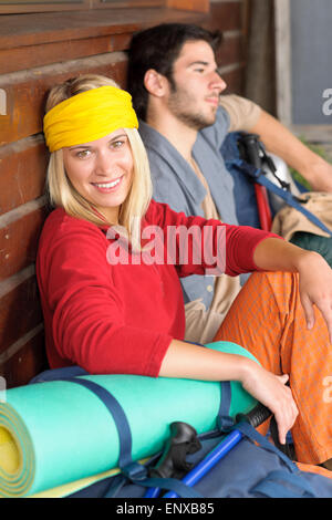 Tramping young couple backpack relax by cottage Stock Photo