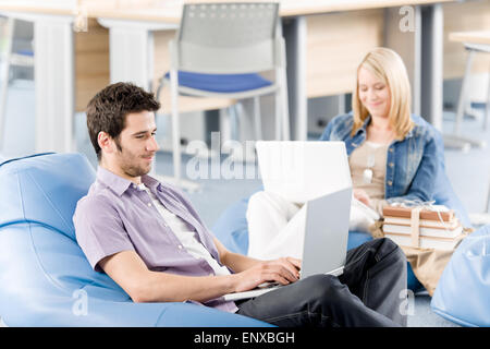 Young students at high-school working on laptop Stock Photo