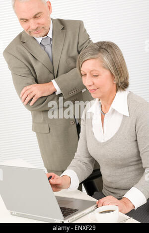 Senior businesspeople in office work on computer Stock Photo