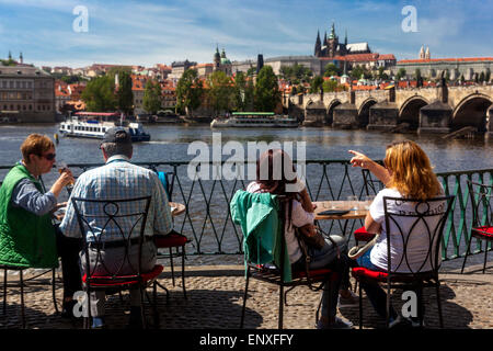 People on terrace restaurant Novotneho Lavka, Prague panorama view, Charles Bridge Vltava River Vltava in Prague Castle, Czech Republic, Europe summer Stock Photo