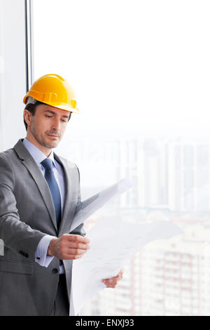 businessman in construction helmet looking at blueprint Stock Photo