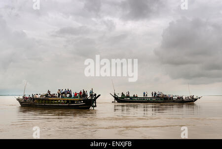 Overcrowded public ferries cross the Brahmaputra river between Jorhat and Majuli Island on a stormy day. Stock Photo