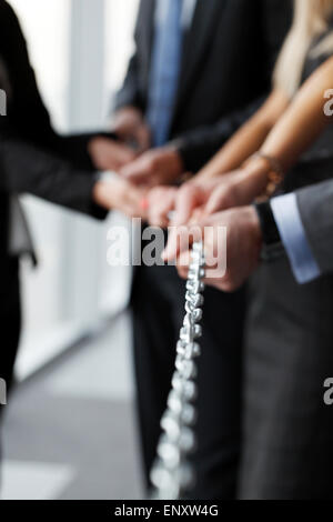 team pulling steel chain together Stock Photo