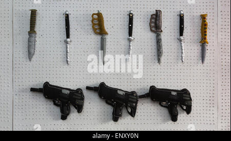 London, UK. 12 May 2015. 'Warmongery: Love is a Warm Gun' by Lucy Sparrow opens at the Boxpark in Bethnal Green Road, Shoreditch, from 12 to 17 May 2015. The textile artist's second large-scale installation is presented in the form of an armoury, where visitors can purchase knives, pistols and explosives entirely made out of felt. The artist, who hand-makes all of her creations over the course of months, brought her work to London last year in the form of the 'Cornershop', an abandoned east London cornershop filled with everyday items such as sweets and newspapers, all made of felt. Stock Photo