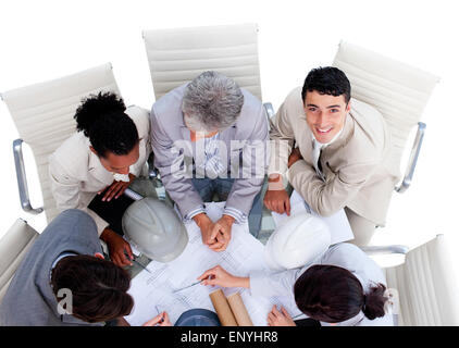 Concentrated international architects studying blueprints in a meeting Stock Photo