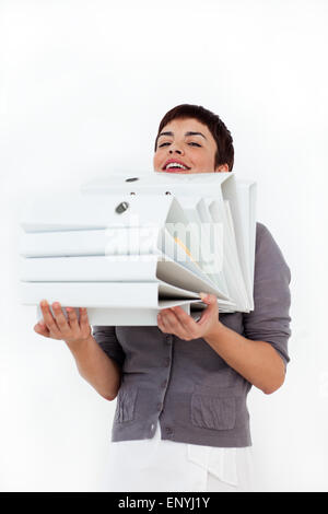 Attractive businesswoman carrying a stack of folders Stock Photo