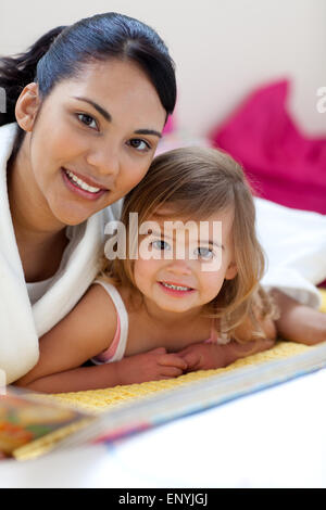 Close-up of a beautiful little girl and her mother reading a book Stock Photo