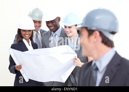 Engineer looking at his team studying a plan Stock Photo