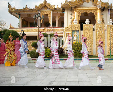 Group of Burmese children dressed in traditional costume walk in line at a ceremony in a Mandalay Pagoda Myanmar Stock Photo