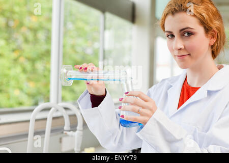 Cute scientist pouring liquid Stock Photo