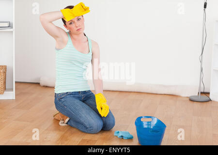 Cute red-haired woman having a break while cleaning the floor Stock Photo