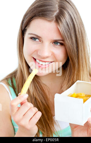 Radiant young woman eating fries against white background Stock Photo
