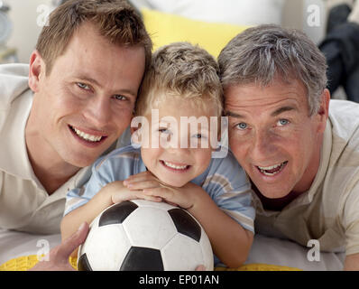 Portrait of smiling son, father and grandfather on floor Stock Photo