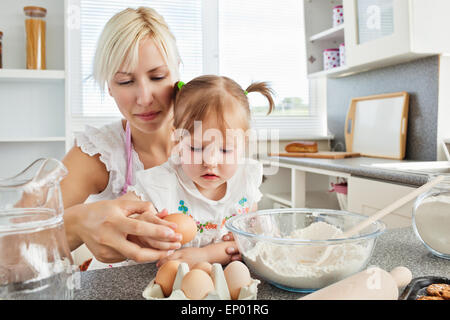 Focused woman baking cookies with her daughter Stock Photo