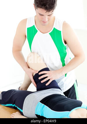 Assertive male physical therapist checking a woman's leg Stock Photo