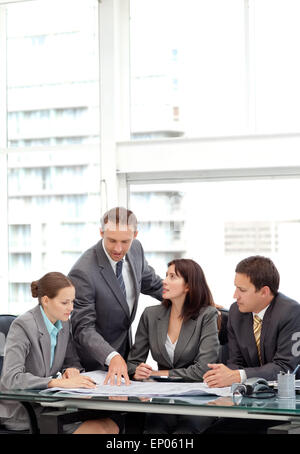 Successful manager showing a plan to his team during a meeting Stock Photo