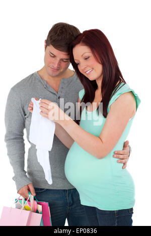 future mom and dad with shopping-bags looking at baby clothes against a white background Stock Photo