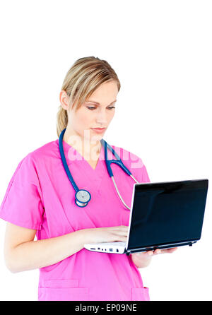 Concentrated female surgeon using a laptop against a white background Stock Photo